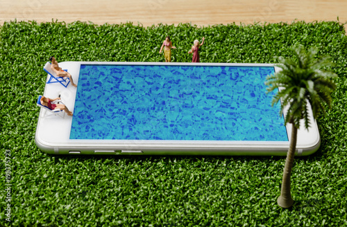 miniature people in swimsuit sitting and relax on mobile phone swimming pool