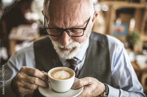 Close up image of senior businessman drinking coffee.