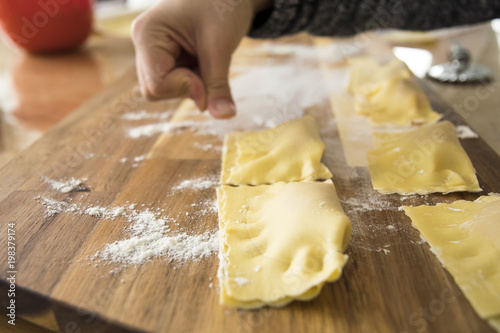 Raw dough for handmade italian ravioli with child hand photo