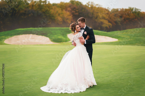 Beautiful bride and groom walking in Autumn Park