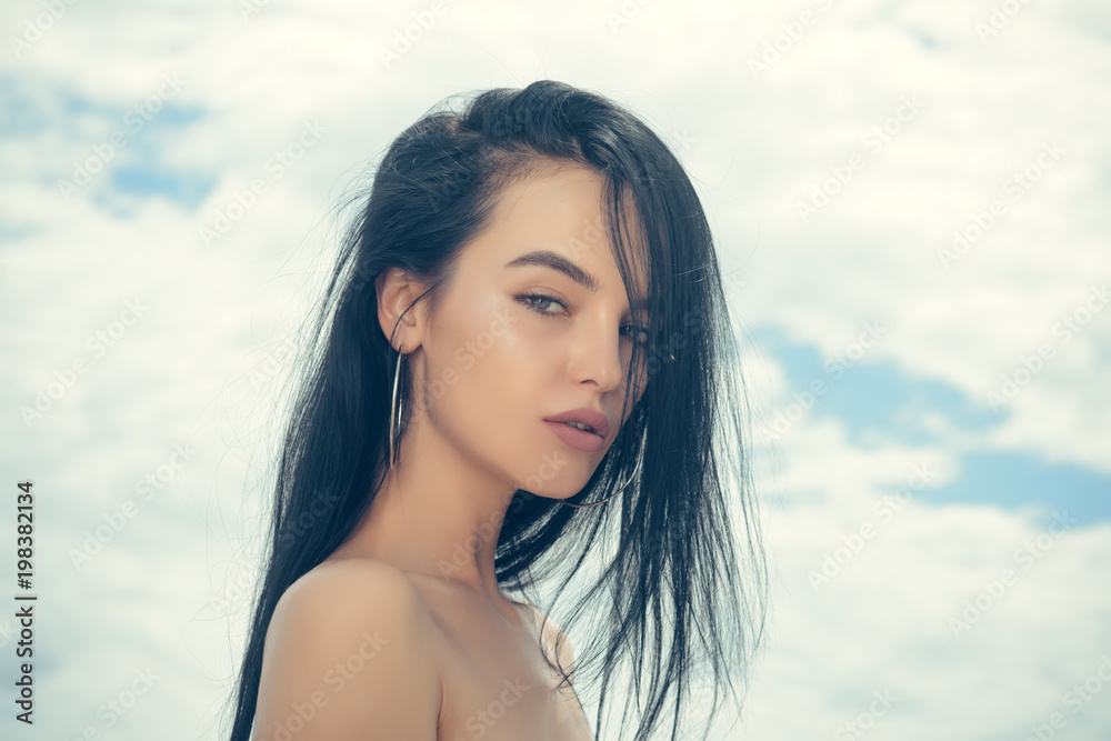 Woman with long brunette hair, hairstyle, on cloudy sky Woman with long brunette hair, hairstyle, on cloudy sky