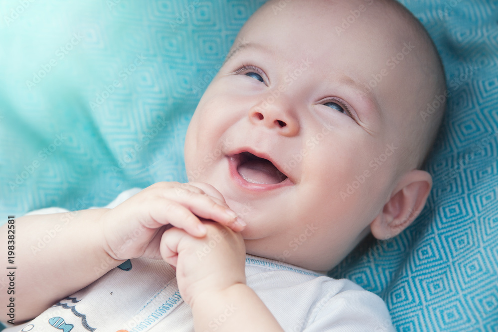 the baby lies in the bed, smiles with delight in the light the baby lies in the bed, smiles with delight in the light