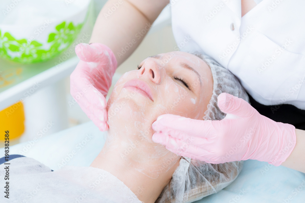 A close-up of the cleaning procedure in the office of cosmetology. Cleaning of the skin with foam. Beautiful girl in beauty salon on facial cleansing procedure. Cosmetologist's job. A close-up of the cleaning procedure in the office of cosmetology. Cleaning of the skin with foam. Beautiful girl in beauty salon on facial cleansing procedure. Cosmetologist's job.