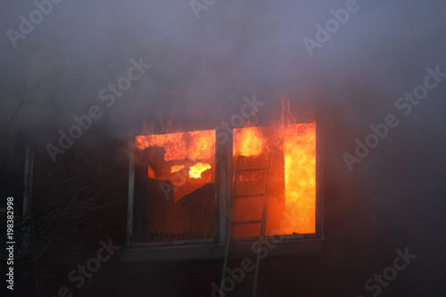 flames and smoke rise from burning building