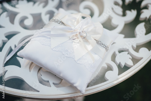 Fototapeta Naklejka Na Ścianę i Meble -  Wedding rings on the white pillow on the ceremony table