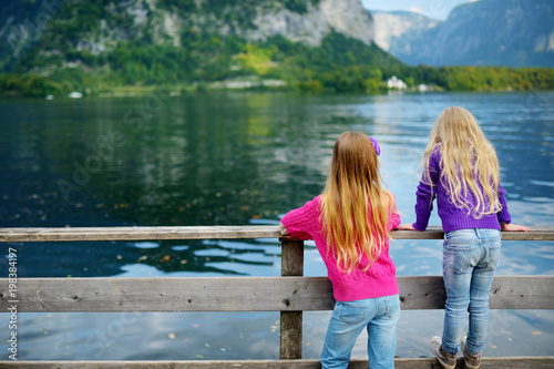 Canvas-taulu Two girls enjoying the scenic view of Hallstatt lakeside town in the Austrian Al