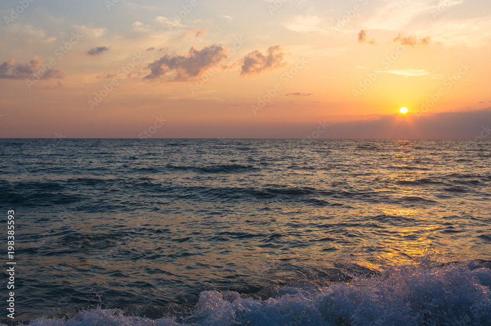 Naklejka premium Amazing sea sunset, the sun, waves, clouds