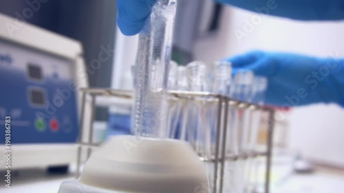 Mixing content of test tube in machine in professional laboratory