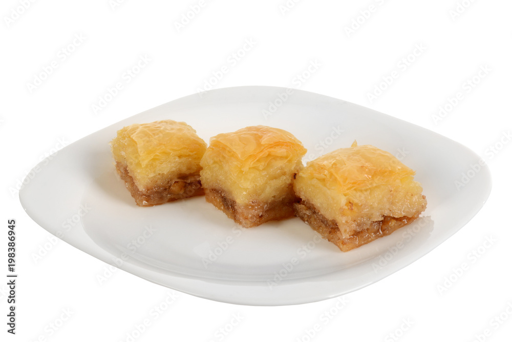 Traditional oriental dessert baklava with syrup.Three pieces of baklava on plate, isolated