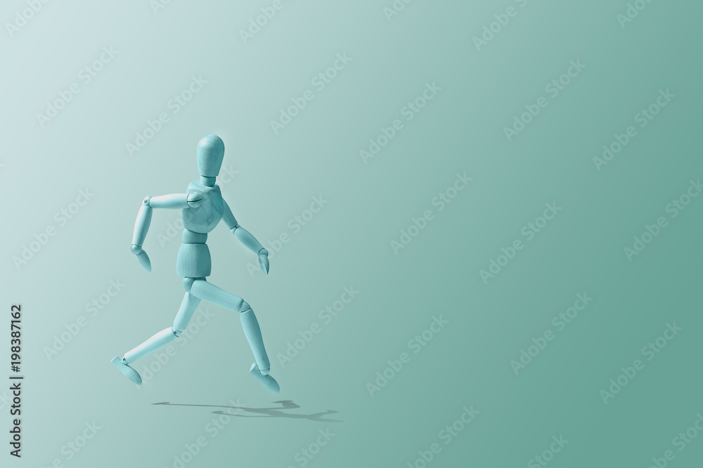 Blue Wooden mannequin in a running pose. Wooden model on the run. Morning running, training. Jogging. The figure of wood runs on a blue pastel background. Caring for physical condition.