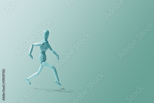 Blue Wooden mannequin in a running pose. Wooden model on the run. Morning running, training. Jogging. The figure of wood runs on a blue pastel background. Caring for physical condition.