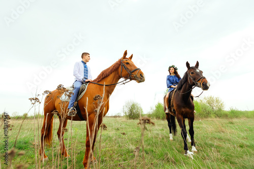 girlfriend and boyfriend riding a horse in the middle of a meadow