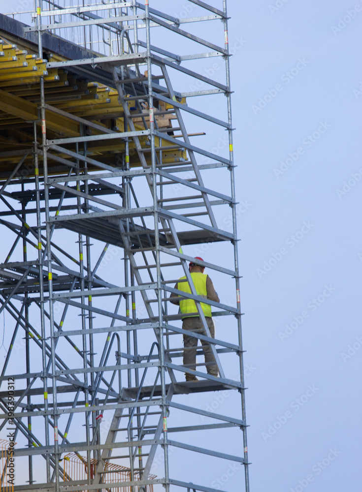 Construction worker on scaffold stairs Construction worker on scaffold stairs
