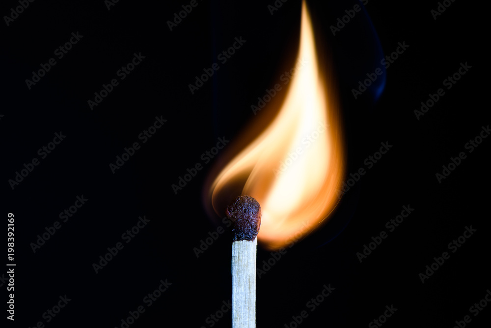 Match with flames in the shape of the upper side of the bulb on a black background closeup Match with flames in the shape of the upper side of the bulb on a black background closeup