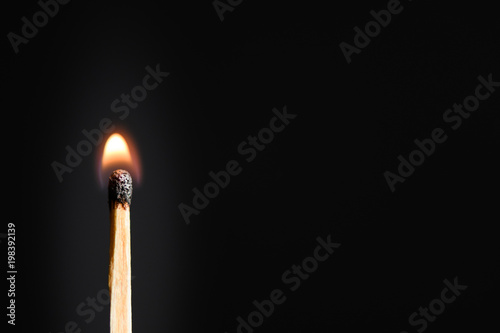 Match with a very weak, discontinuous flames on a black background closeup