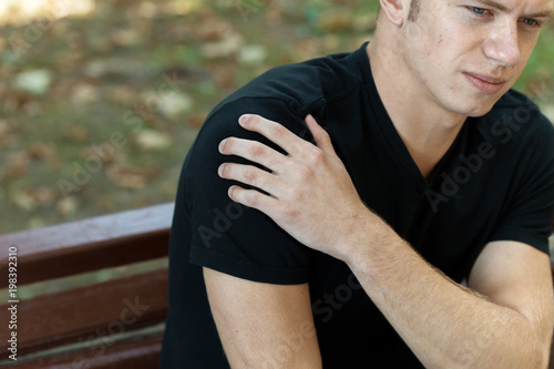 Outdore portrait of a man having shoulder pain