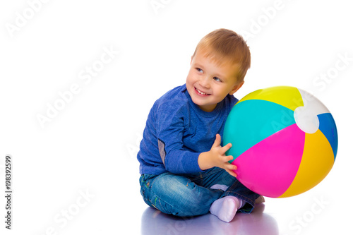 A little boy is playing with a ball.