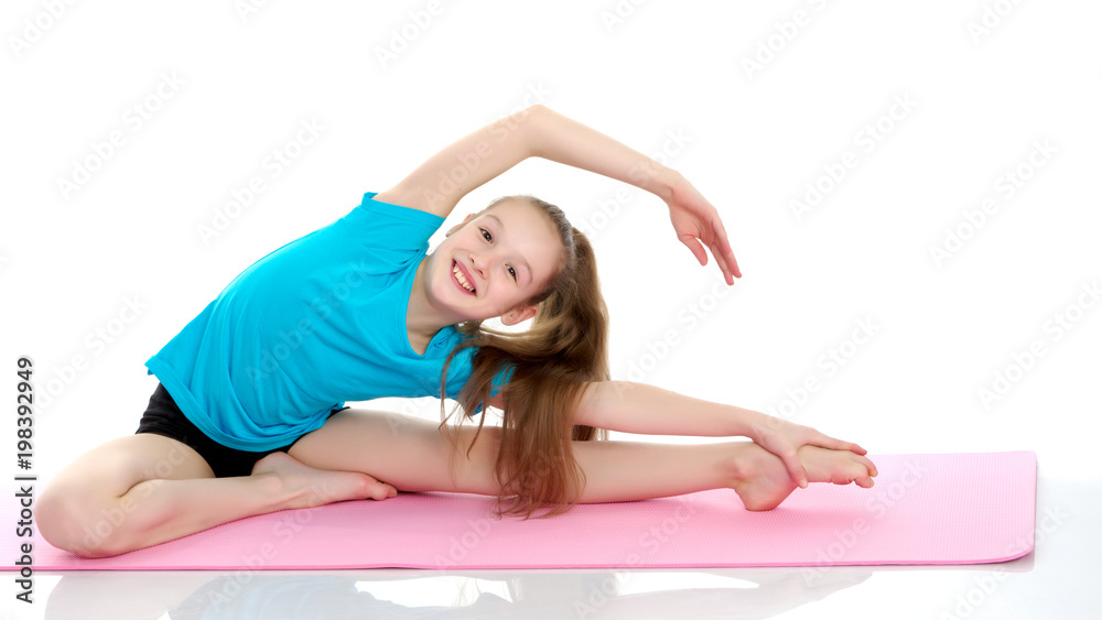 The little gymnast perform an acrobatic element on the floor. The little gymnast perform an acrobatic element on the floor.
