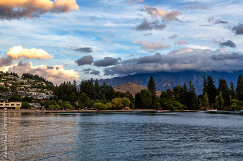 Evening view of Queenstown and lake Wakatipu in New Zealand with beautiful mountains covered with clouds.