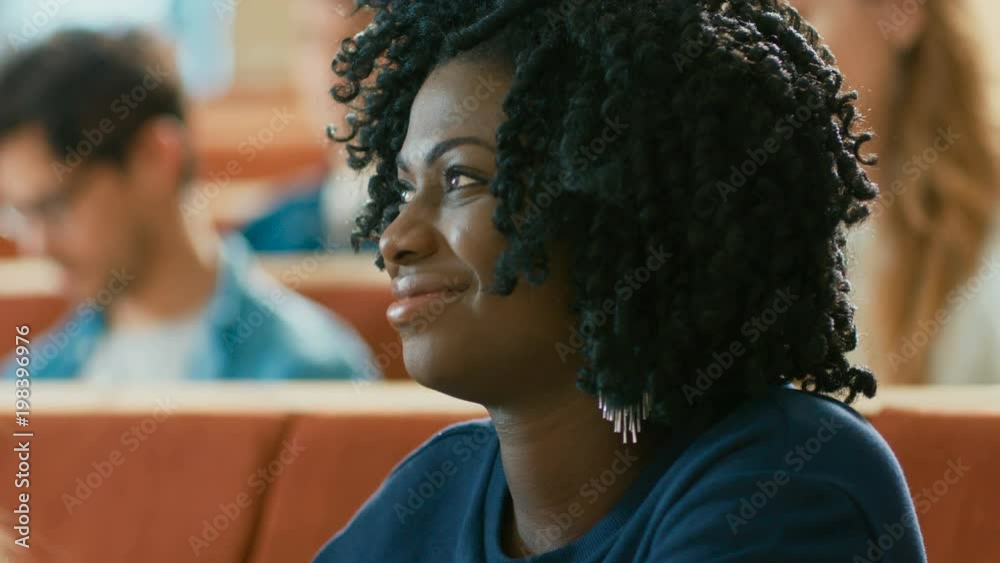 Portrait of a Smart and Beautiful Young Black Girl Listening to a Lecture in a Classroom Full of Multi Ethnic Students. Shot on RED EPIC-W 8K Helium Cinema Camera. Portrait of a Smart and Beautiful Young Black Girl Listening to a Lecture in a Classroom Full of Multi Ethnic Students. Shot on RED EPIC-W 8K Helium Cinema Camera.