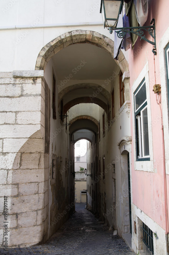 Narrow and tall archway in Alfama district, Lisbon
