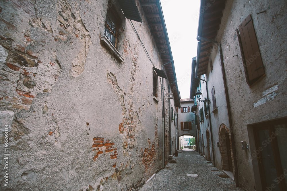 old narrow alley in tuscan village - antique italian lane in Montalcino, Tuscany, Italy.