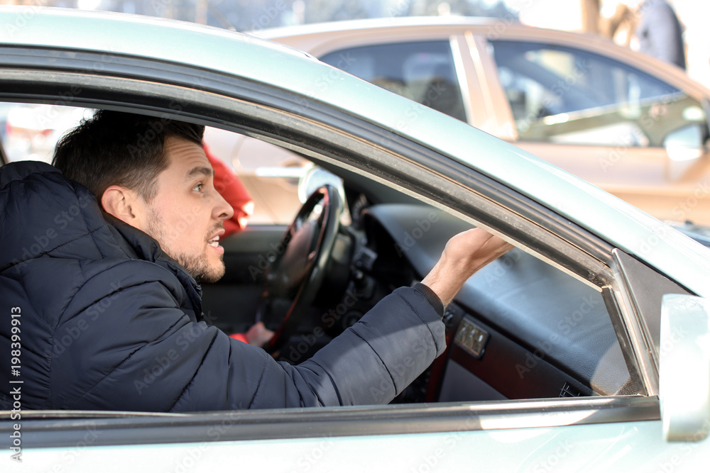 Emotional man inside car in traffic jam