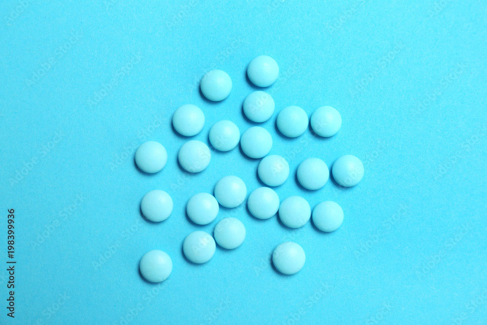 Blue pills on color background