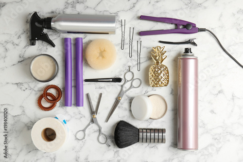 Flat lay composition with professional hairdresser tools on marble background