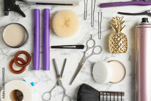 Flat lay composition with professional hairdresser tools on marble background