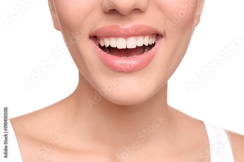 Young woman with beautiful smile on white background  closeup. Teeth whitening