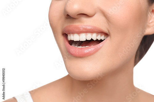 Young woman with beautiful smile on white background, closeup. Teeth whitening