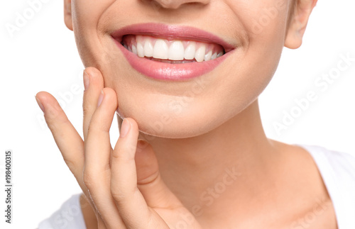 Young woman with beautiful smile on white background, closeup. Teeth whitening