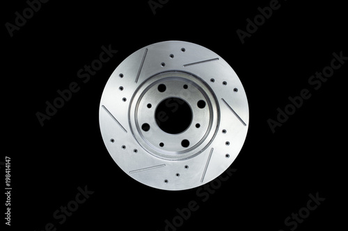 Disc brake isolated on black background, Metal car brake disc with multiple cooling grooves. Automotive parts concept.