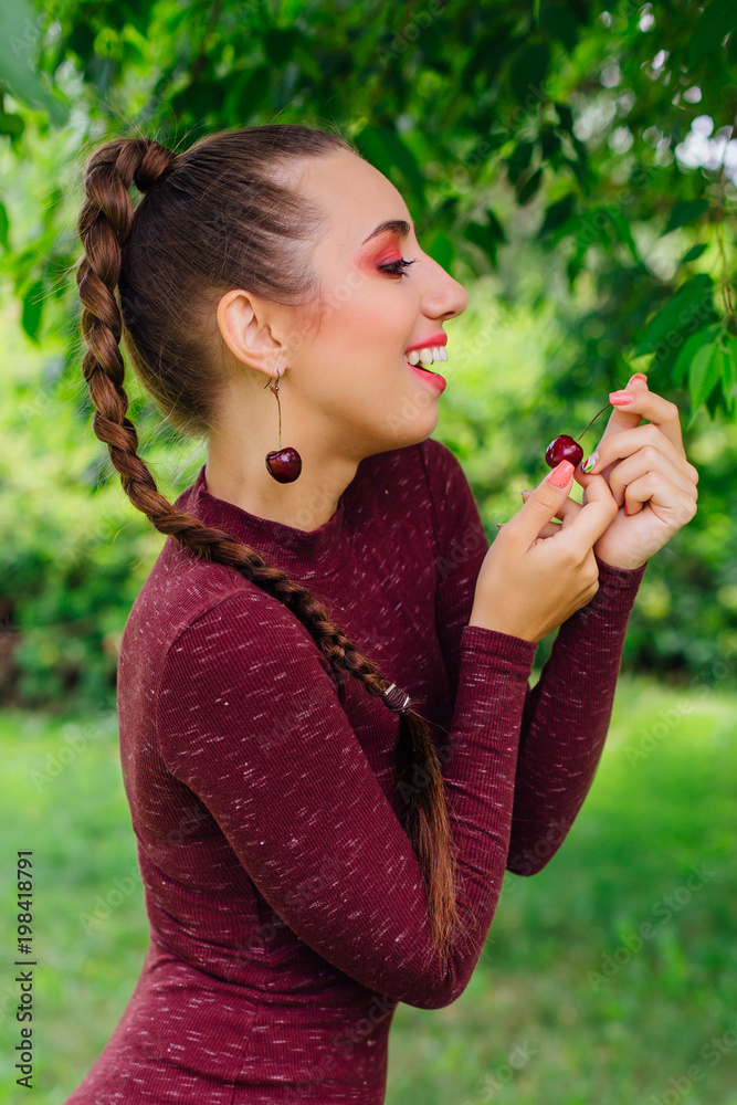 Beautiful young woman with long braid and natural cherry earrings. Beautiful young woman with long braid and natural cherry earrings.