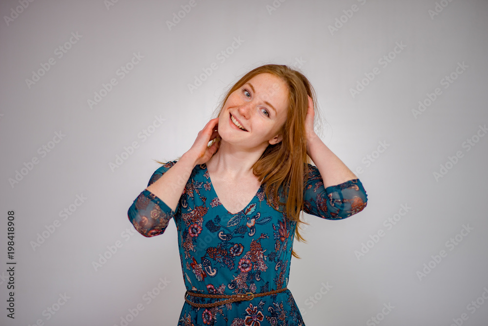 Cute beautiful red-haired girl shows different emotions in different poses on different background in different clothes