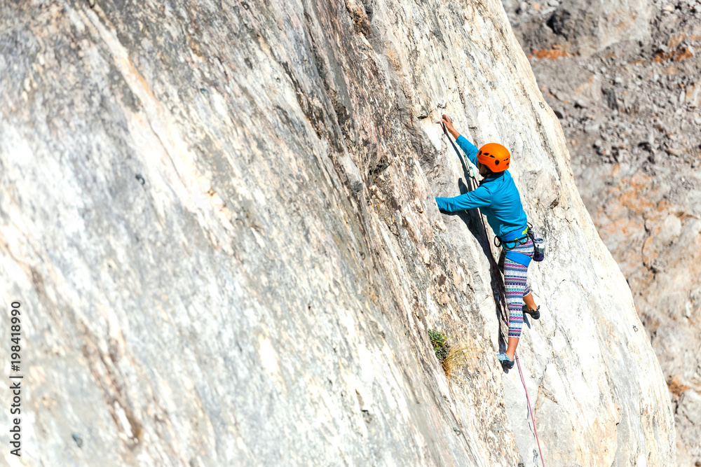 Woman in helmet on the rock.