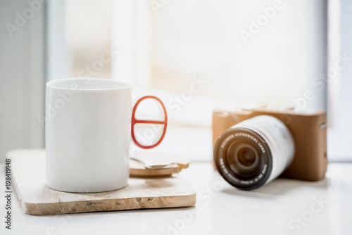 cup of coffee or tea and classic camera on white table