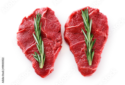 Fresh raw beef steaks and rosemary isolated on white background.