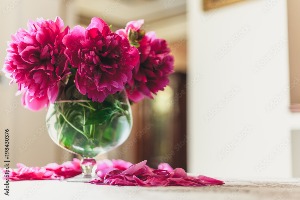 red peonies in glass vase stand on table red peonies in glass vase stand on table