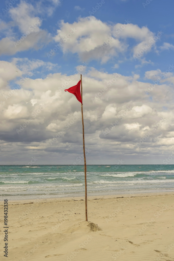 Red flag on the beach prohibiting bathing and entering the water Red flag on the beach prohibiting bathing and entering the water