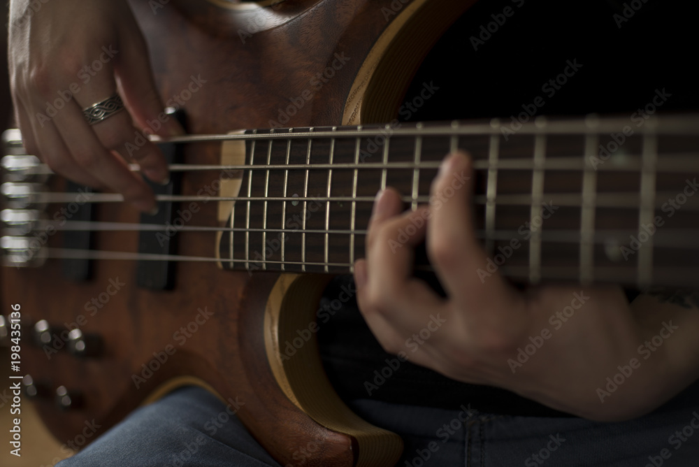 Fototapeta premium Hands of rock musician playing the electric bass guitar
