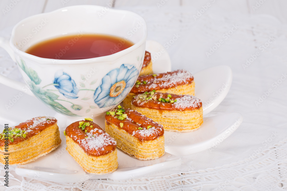 Light Crunchy Puff Layered Pastry Garnished With Pistachios & Coconut Flakes And Cup Of Tea Popular Persian Sweets In Iran Called Zaboon Or Zaban Light Crunchy Puff Layered Pastry Garnished With Pistachios & Coconut Flakes And Cup Of Tea Popular Persian Sweets In Iran Called Zaboon Or Zaban
