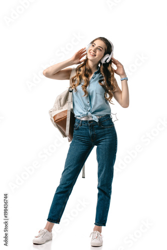 happy beautiful student listening to music with headphones isolated on white