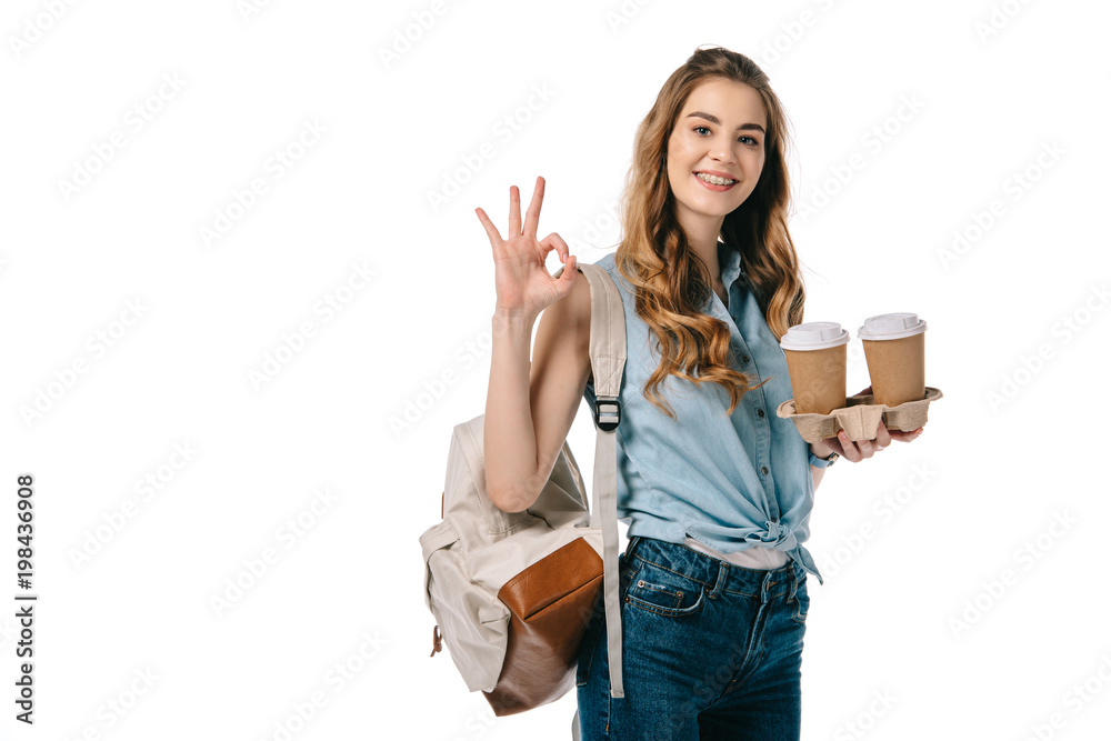 beautiful student showing okay gesture and holding coffee isolated on white beautiful student showing okay gesture and holding coffee isolated on white