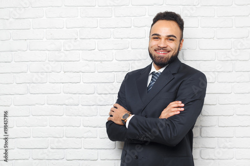 Young fashionable men in a suit against brick wall