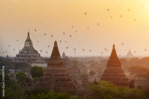 Hot air balloons flying over ancient pagodas with beautiful sunrise sky at Bagan  Myanmar. Asia travel destination.