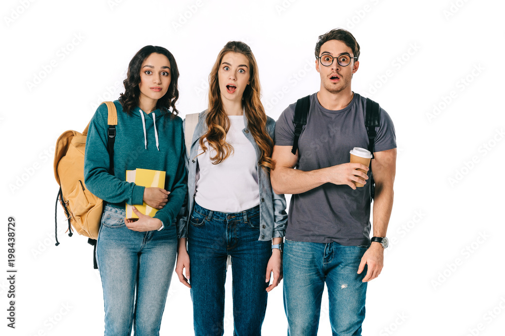 Fototapeta premium shocked multicultural students looking at camera isolated on white