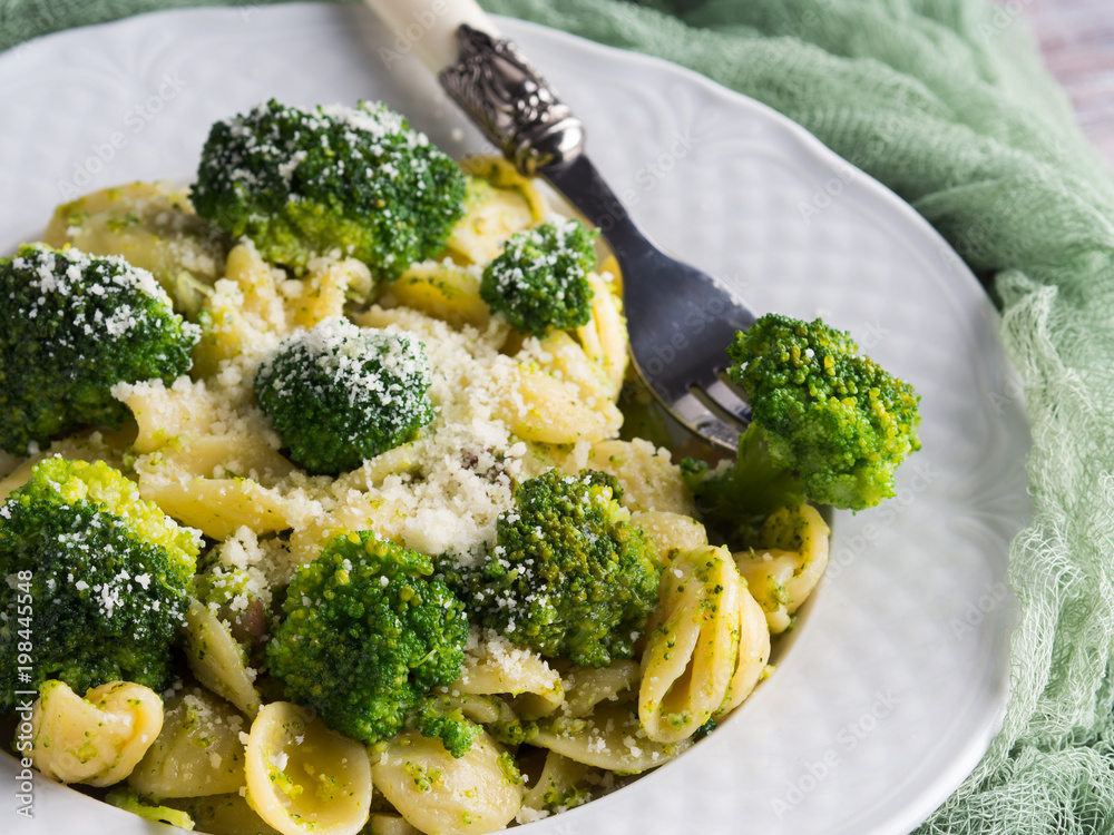 Orecchiette pasta with broccoli in white dish on wooden table. Easy recipe for lunch. Orecchiette pasta with broccoli in white dish on wooden table. Easy recipe for lunch.