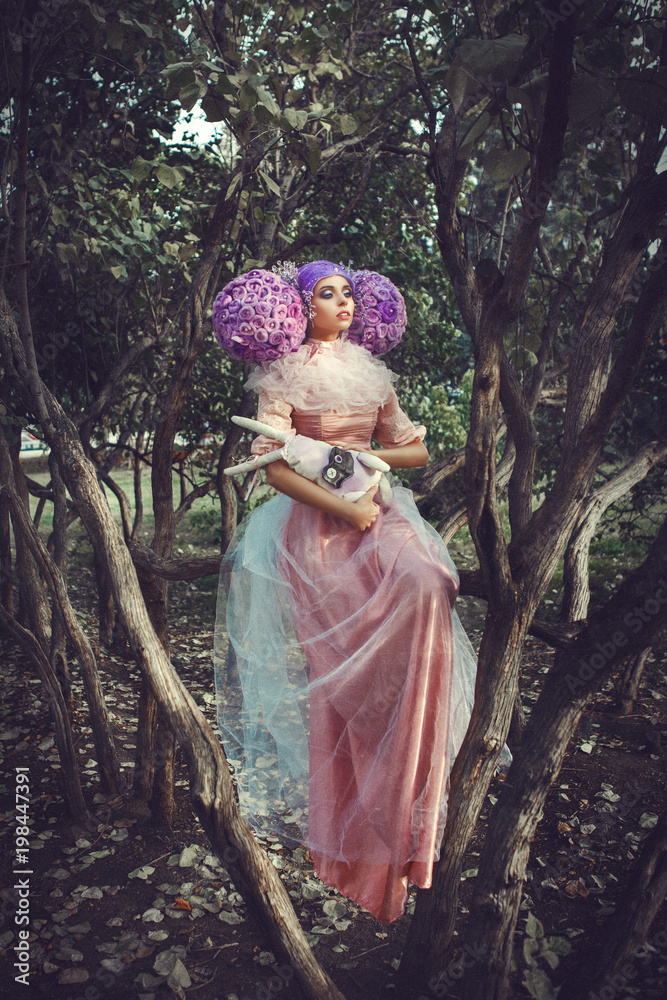 Obraz premium Beautiful model wearing pink dress is posing in a creative wig 